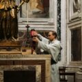 priest lighting candles in a roman church