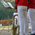 marching band members with brass instrument outdoors